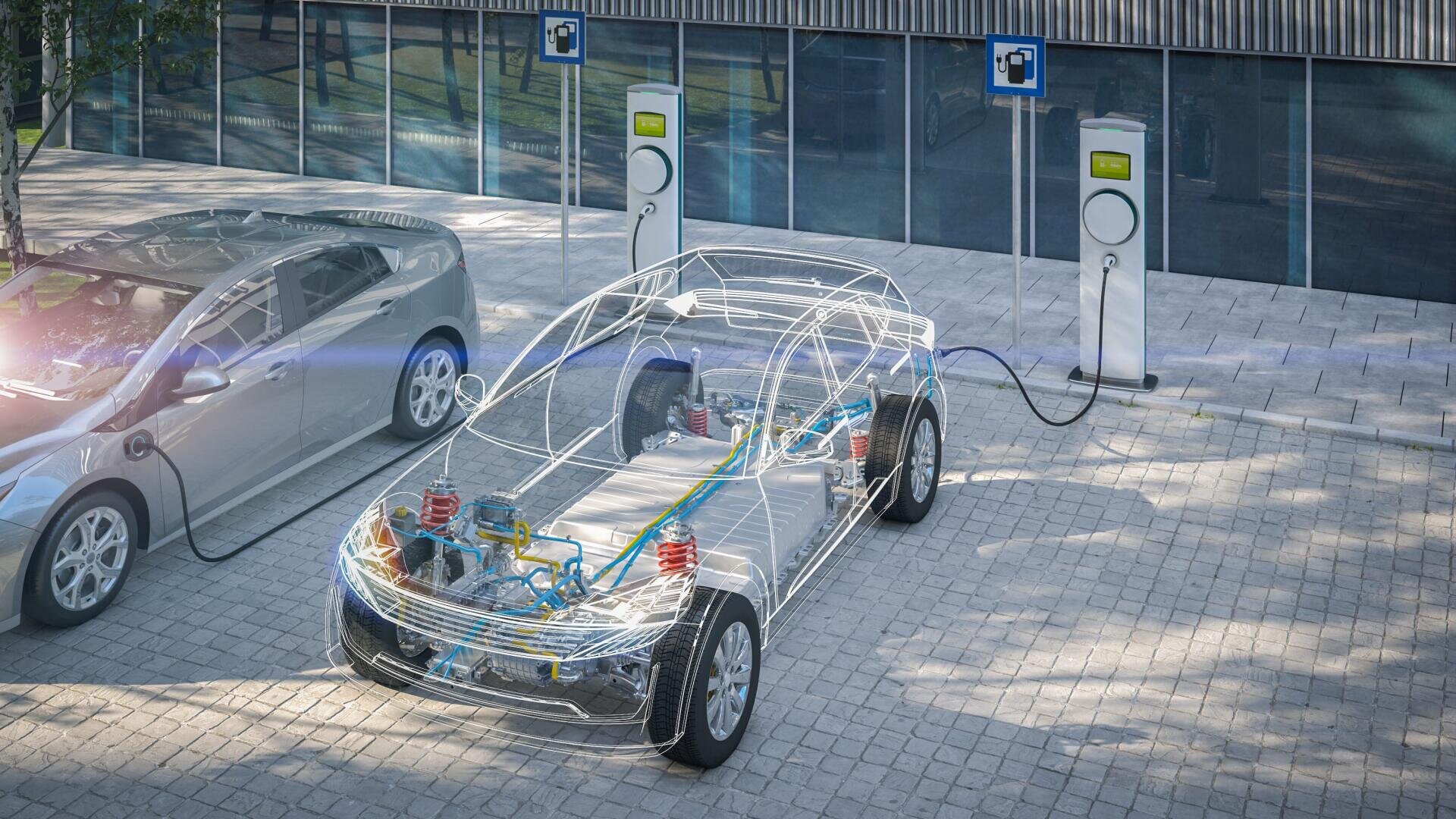 Ein Auto mit einem transparenten Overlay, das seine internen elektrischen Komponenten zeigt, lädt an einer Elektrofahrzeug-Station neben einem anderen Auto vor einem modernen Gebäude.
