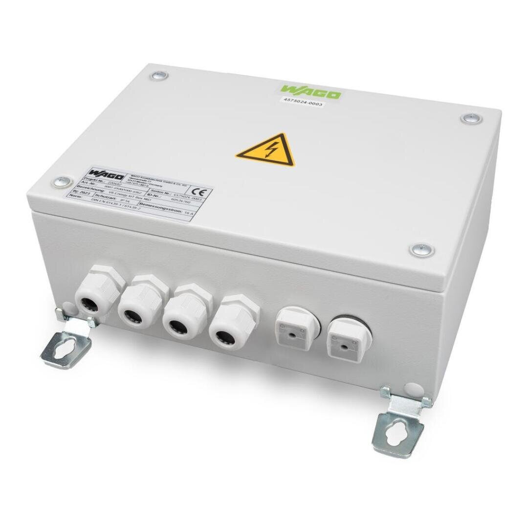 Ein weißer, rechteckiger elektrischer Verteilerkasten mit einem Warnsymbol auf der Oberseite, beschriftet mit "WAGO". Er verfügt über mehrere Kabeleinführungen mit Steckern und zwei Befestigungsklammern am Boden.