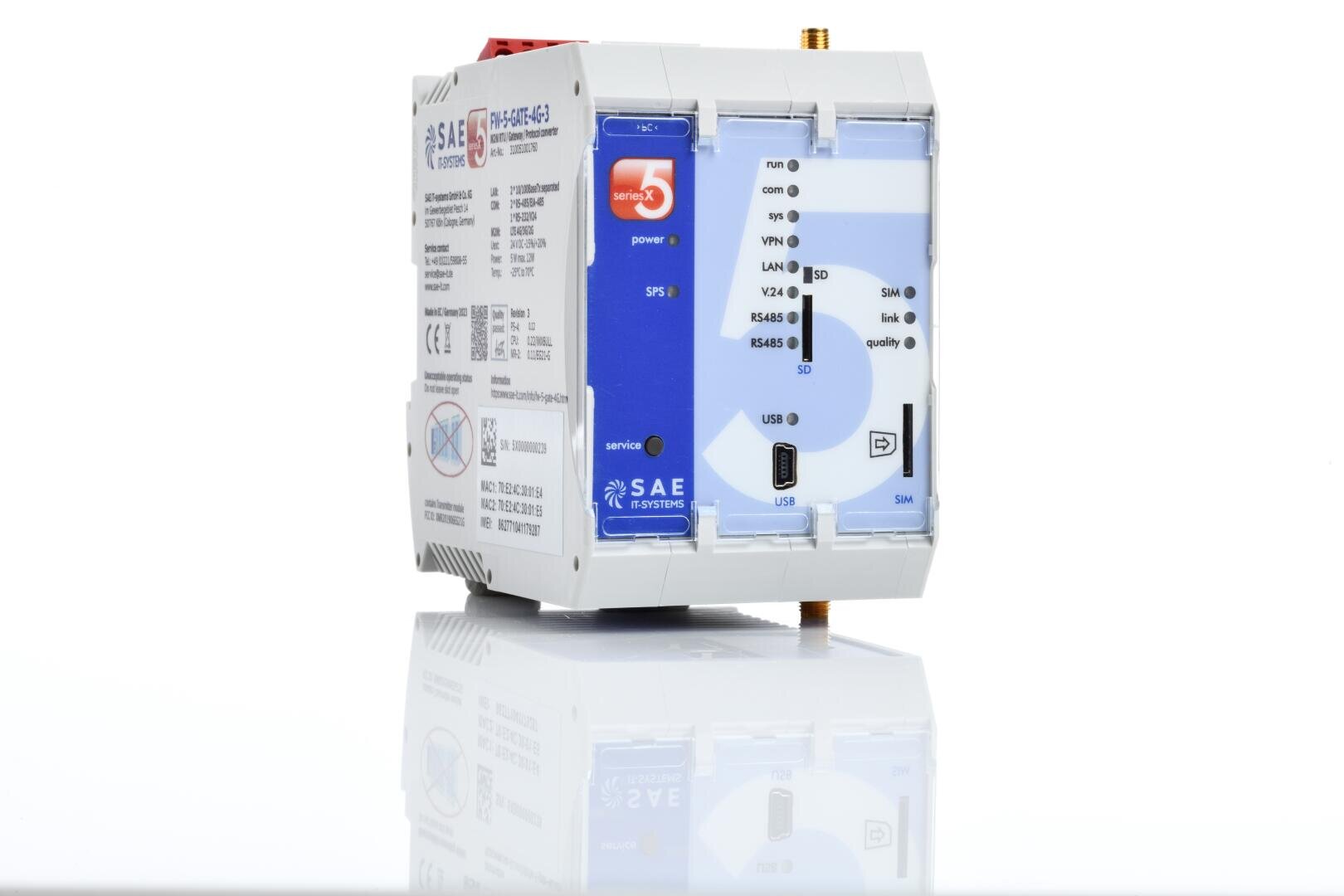 Ein weißes und blaues elektronisches Industriegerät mit verschiedenen Anschlüssen, Aufklebern und Anzeigeleuchten, einschließlich USB-Anschlüssen und Kommunikationsanschlüssen, das auf einer reflektierenden weißen Oberfläche steht.