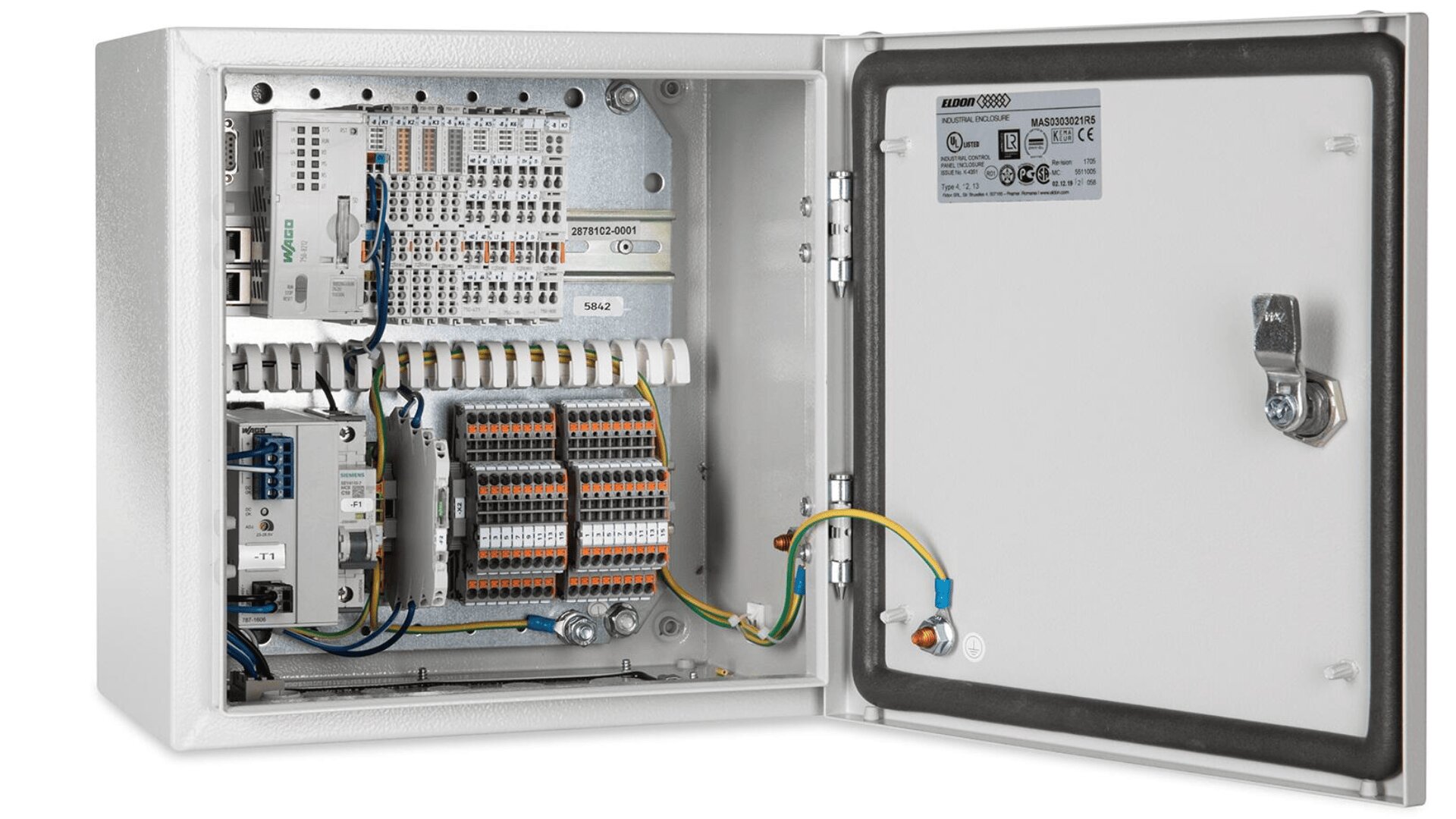 A metal electrical control panel with the door open, showing wiring, terminal blocks, relays, and various electrical components organized inside. A label with specifications is attached to the inside of the door.
