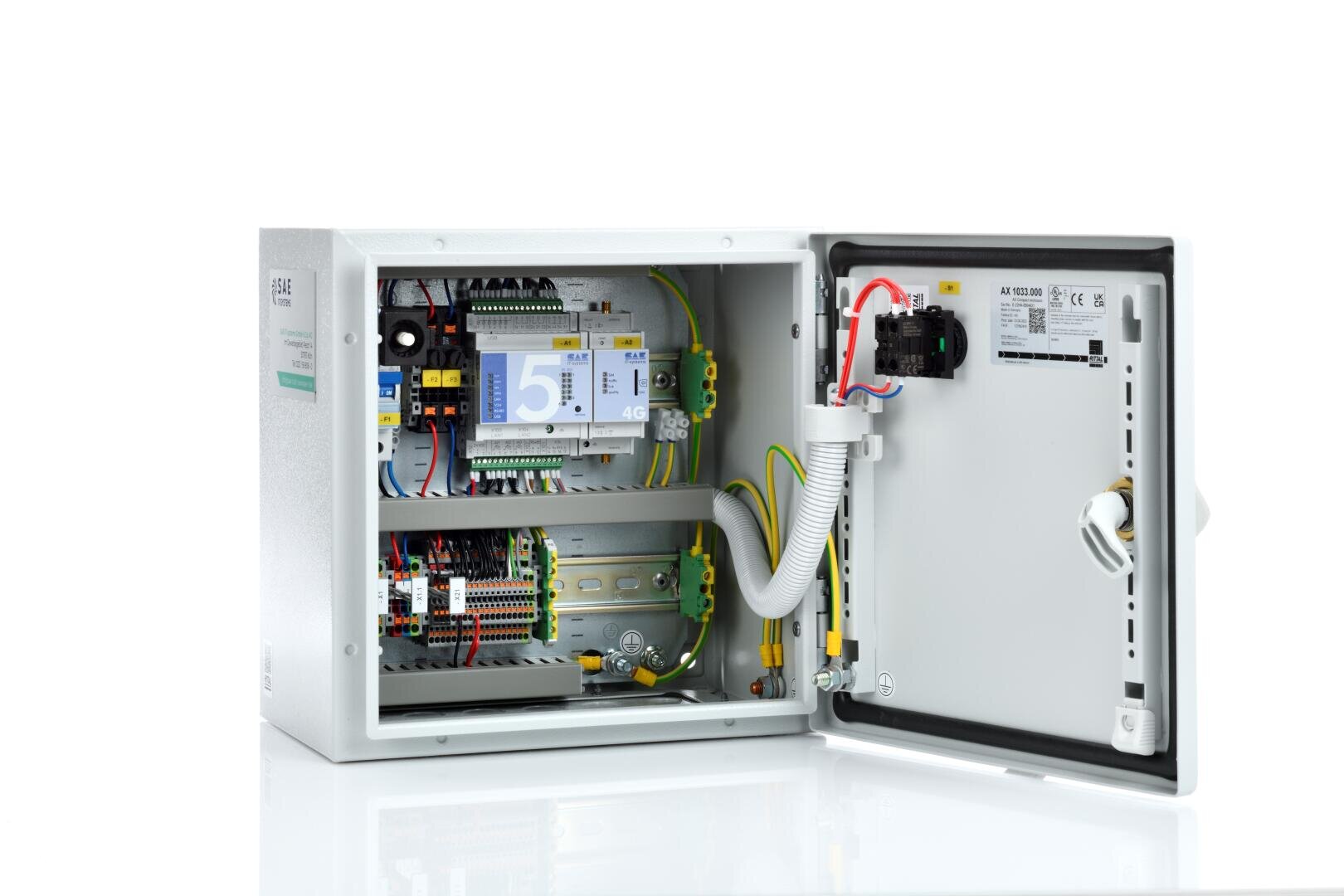 Eine geöffnete elektrische Schalttafel mit Verdrahtung, Leiterplatten, Relais und elektronischen Bauteilen, wobei die Tür geöffnet ist, um die internen Mechanismen und einen weißen Hintergrund zu zeigen.