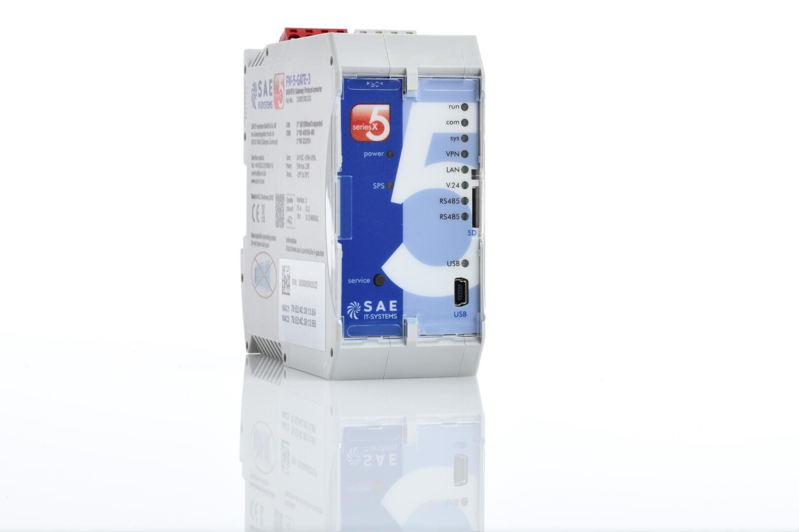Ein weißes und blaues elektronisches Industriegerät mit mehreren beschrifteten Anschlüssen, Tasten und Anzeigeleuchten auf der Vorderseite, das aufrecht auf einer reflektierenden Oberfläche steht.