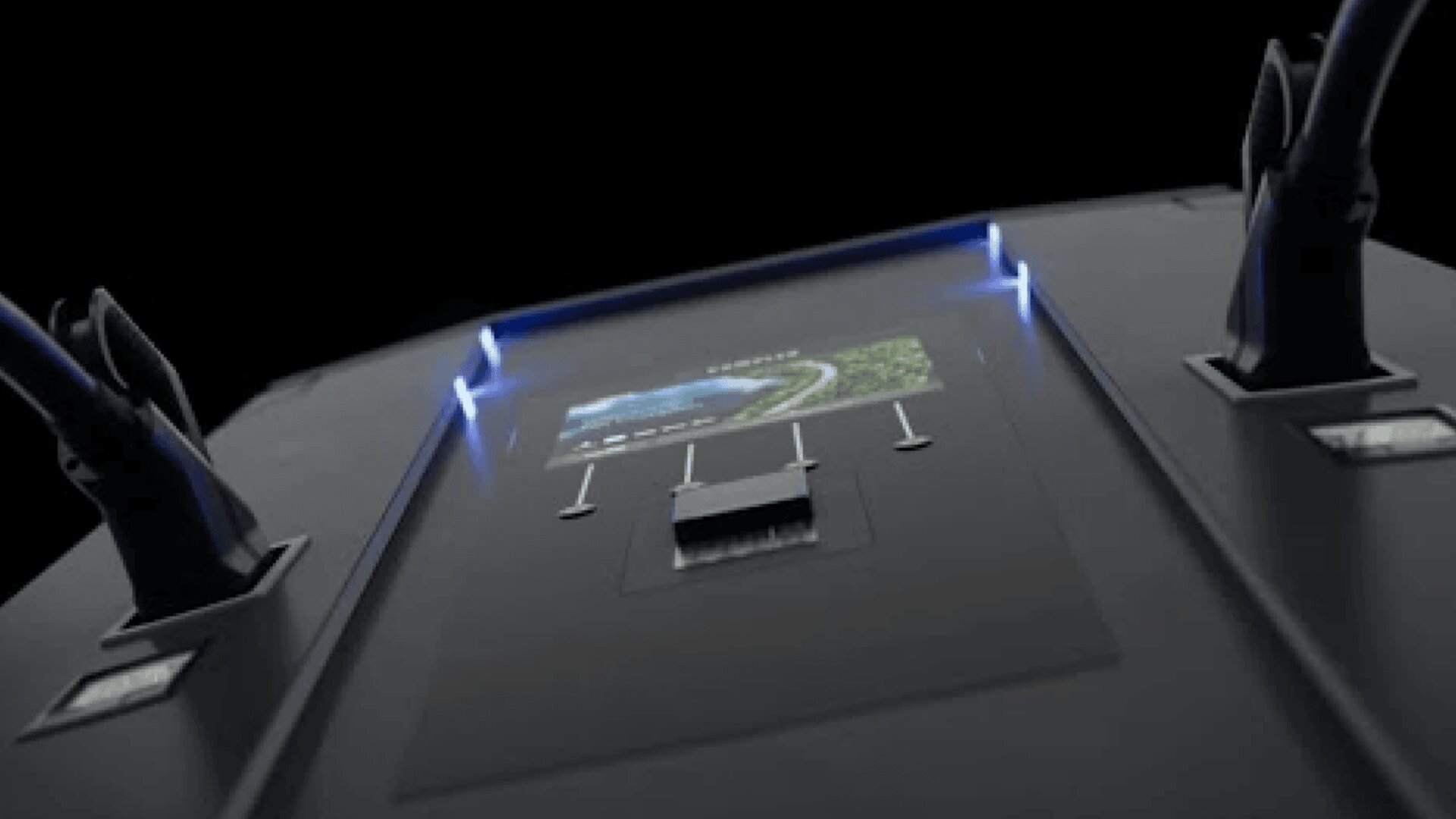 Nahaufnahme eines elektronischen Geräts mit Anschlüssen und angeschlossenen Kabeln, auf dem ein kleiner Bildschirm eine Straße und eine Landschaft anzeigt, beleuchtet von blauen LED-Lichtern.