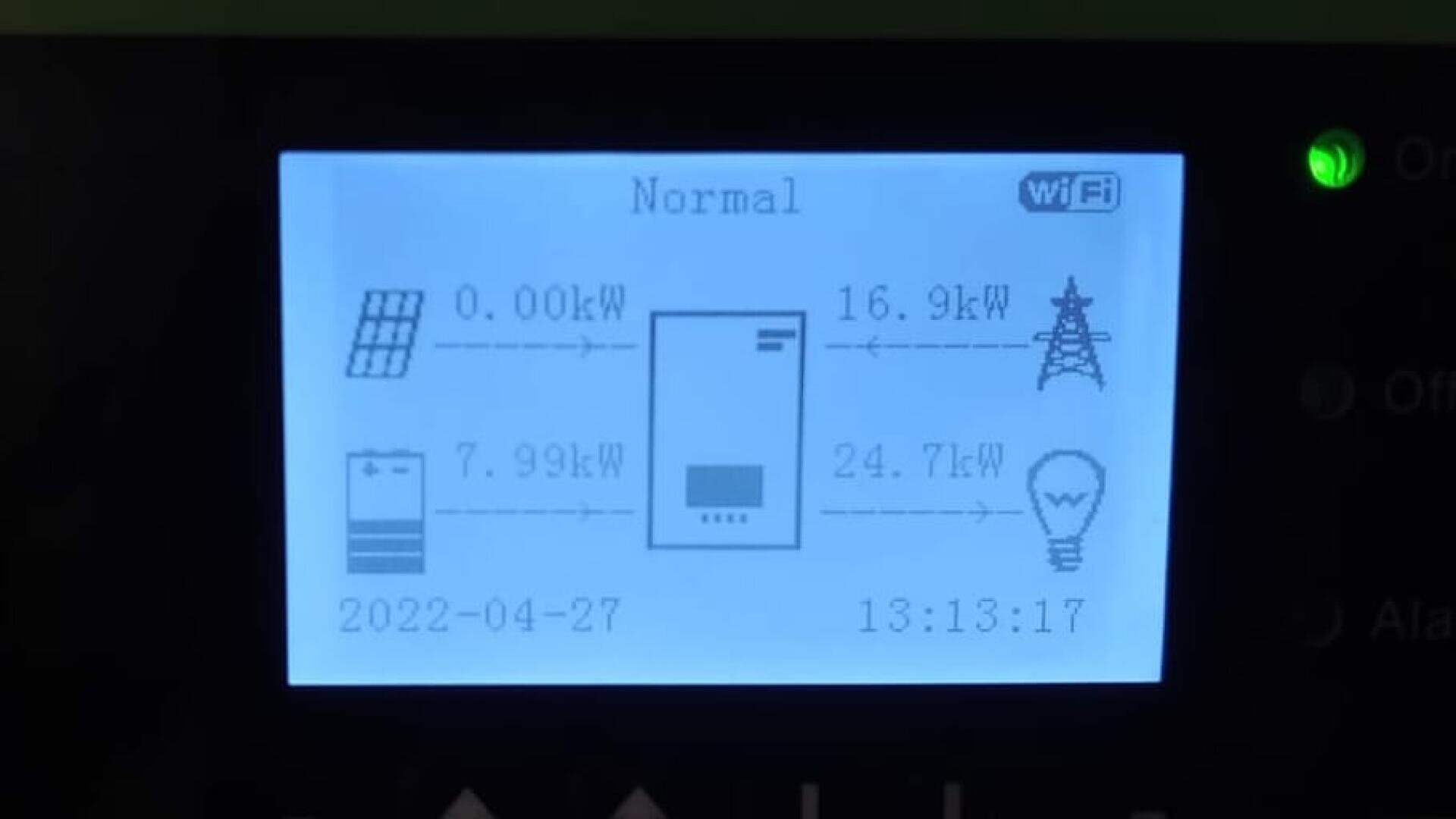 LCD screen showing a solar power system status: 0.00kW from solar panels, 7.99kW from battery, 16.9kW to grid, 24.7kW to load. Date is 2022-04-27, time is 13:13:17. WiFi symbol displayed.