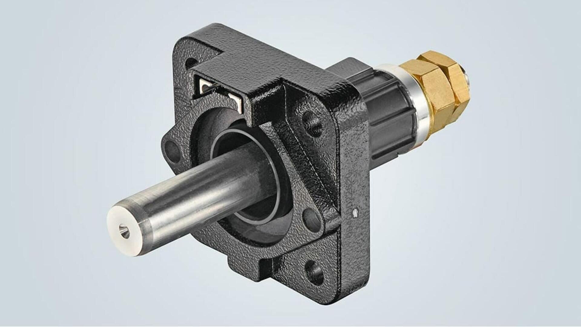A close-up view of a black metal flange bearing with a cylindrical steel shaft protruding and a brass threaded fitting at the end, against a light gray background.