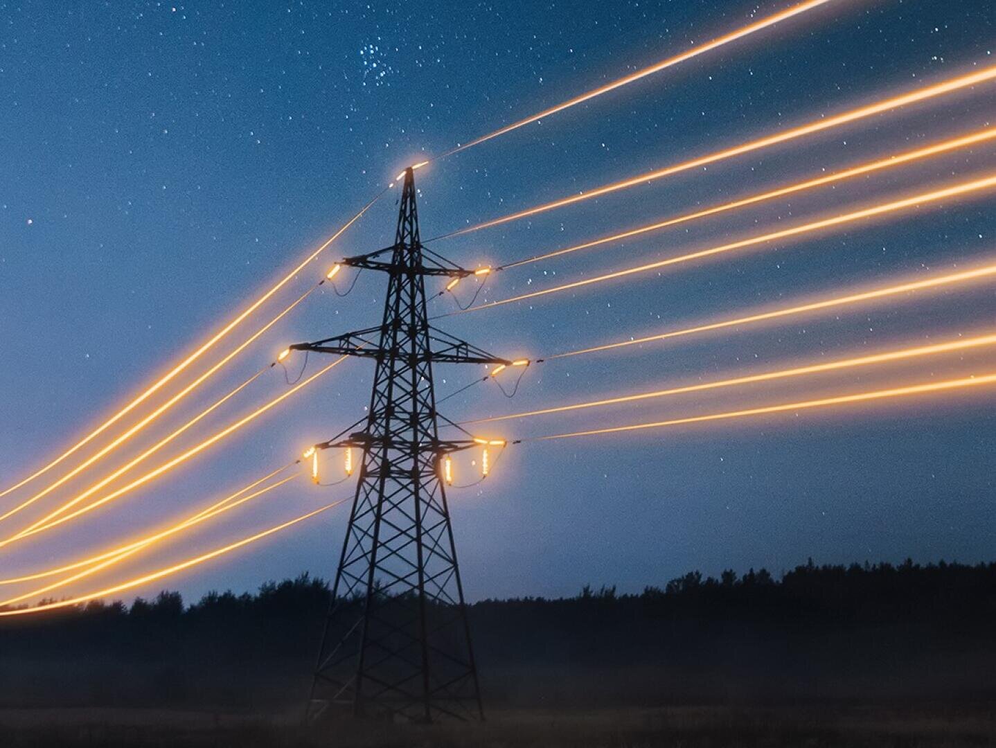 Ein Strommast ragt vor dem Nachthimmel empor, während leuchtend orangefarbene Lichtspuren den Stromfluss entlang der Kabel symbolisieren und über der dunklen Landschaft Sterne zu sehen sind.