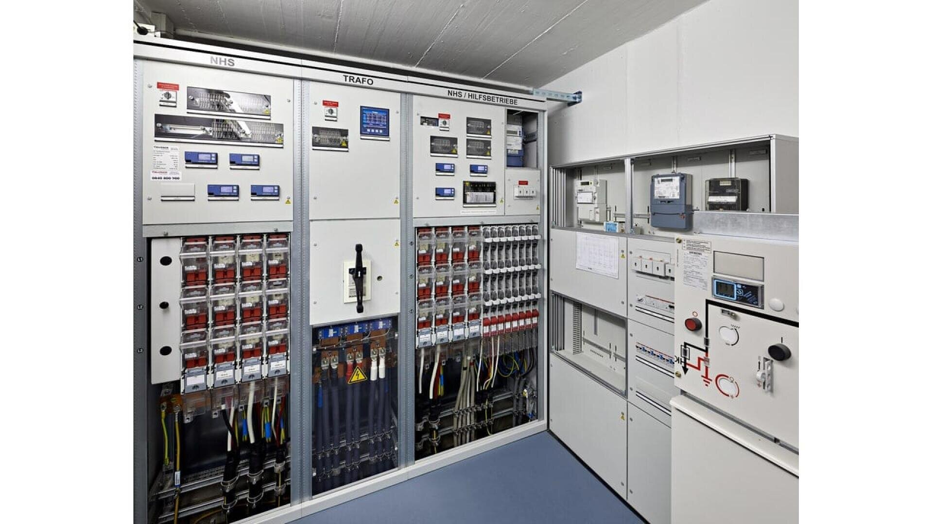 A room with a large cabinet with many switches and wires.