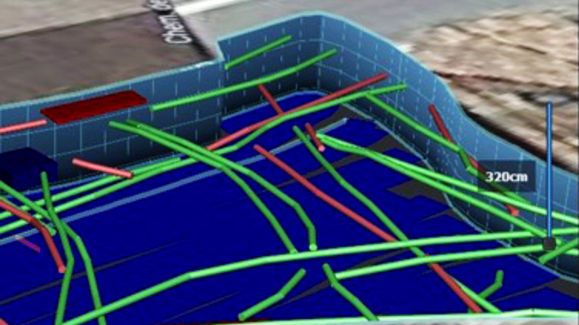 Das digitale 3D-Modell zeigt einen blauen, ummauerten Bereich mit zahlreichen sich kreuzenden grünen und roten Linien im Inneren, die möglicherweise unterirdische Rohre oder Kabel darstellen. Ein Etikett zeigt eine Messung von 320 cm an.