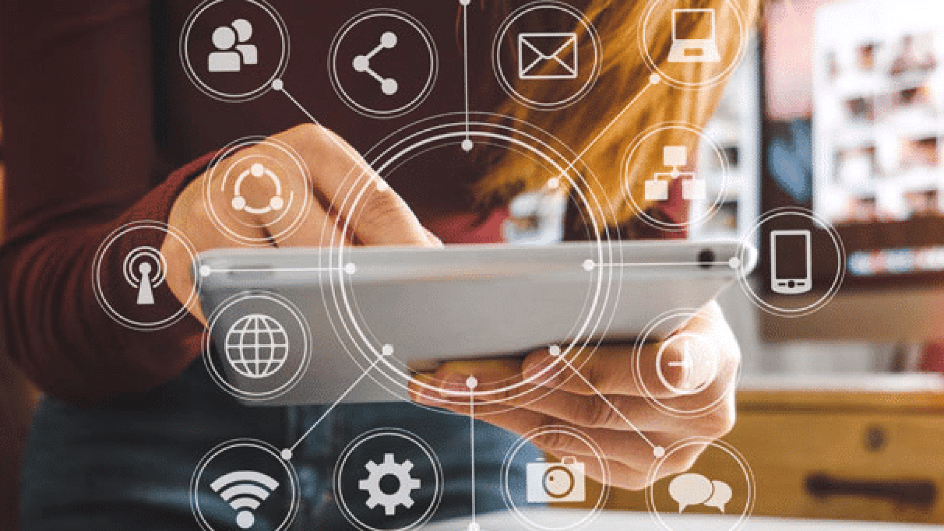 Eine Person, die ein Tablet benutzt, mit verschiedenen digitalen Symbolen wie E-Mail, Wi-Fi, Cloud und Social-Media-Grafiken überlagert, die Konnektivität und Technologie darstellen.
