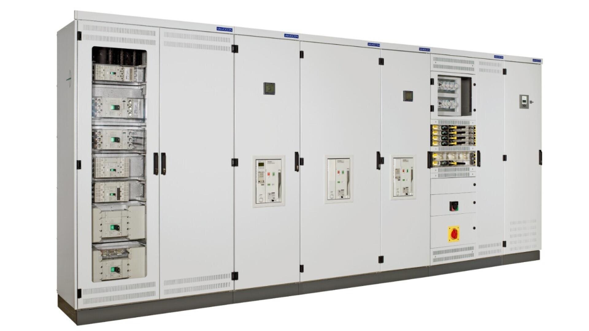 A large white electrical control panel with multiple cabinets, switches, meters, buttons, and circuit breakers, used for managing and distributing electrical power.