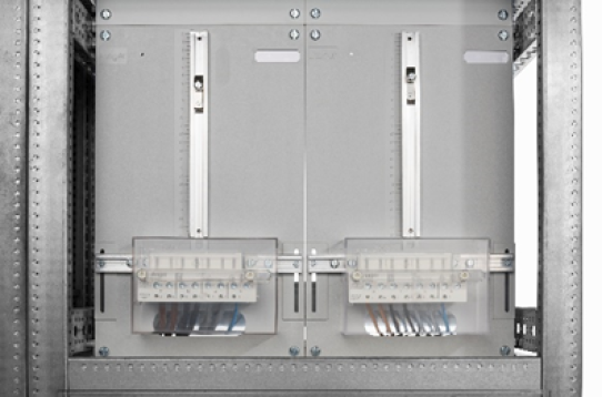 Close-up of an electrical panel with two transparent covers showing internal wiring and connections, housed within a metal enclosure.
